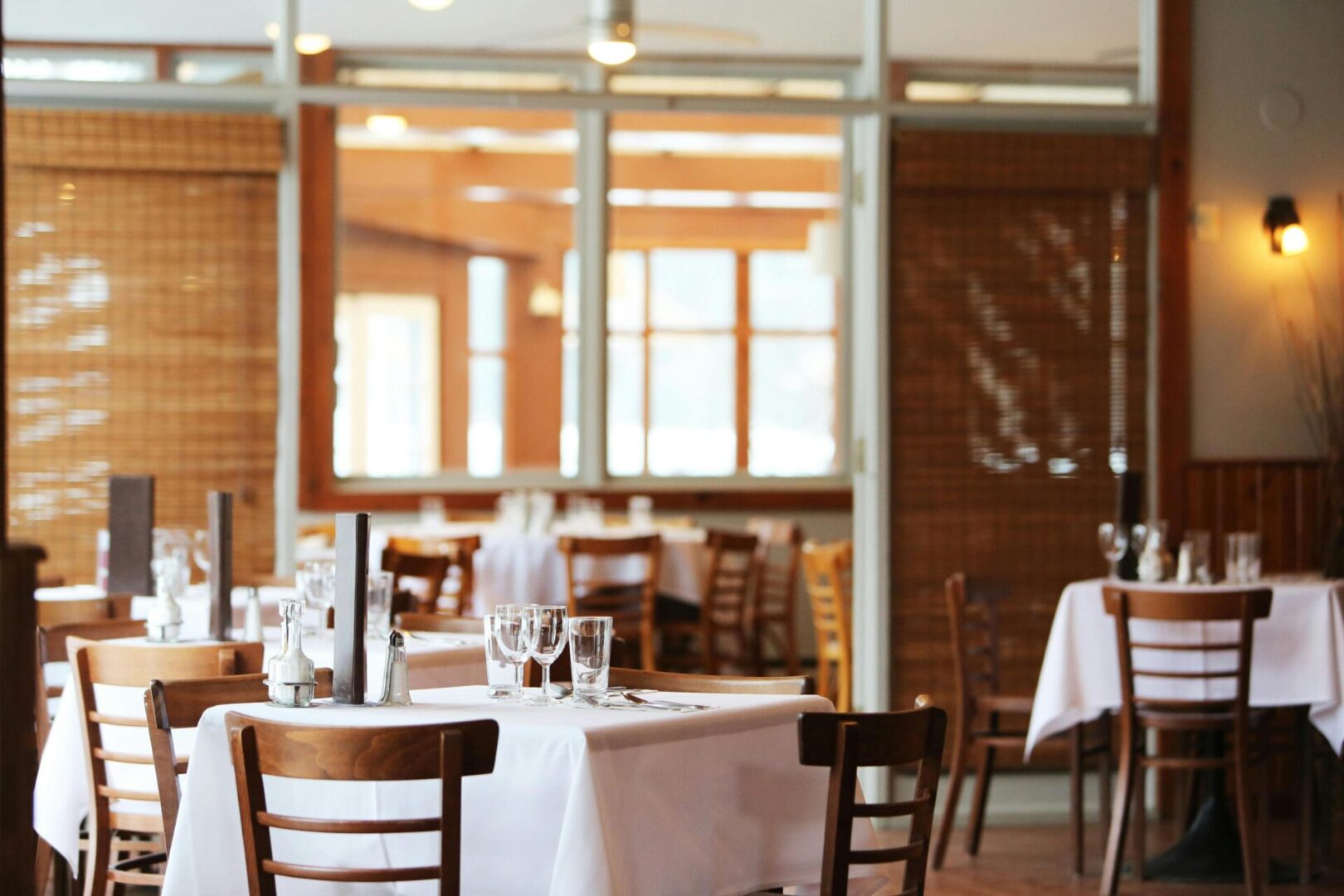 A restaurant with tables and chairs set up for dinner.